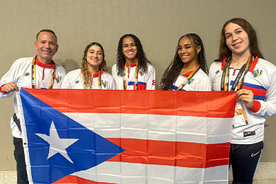 El equipo femenino de las Jerezanas de la UPR de Río Piedras y su entrandor Grimaldo Maldonado previo a la Ceremonia de Inaguración de FISU América.jpg (Suministrada)